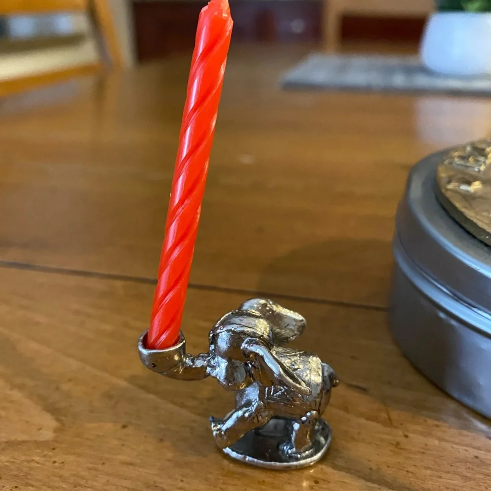 Set of animal candle holders stored in a metal tin.